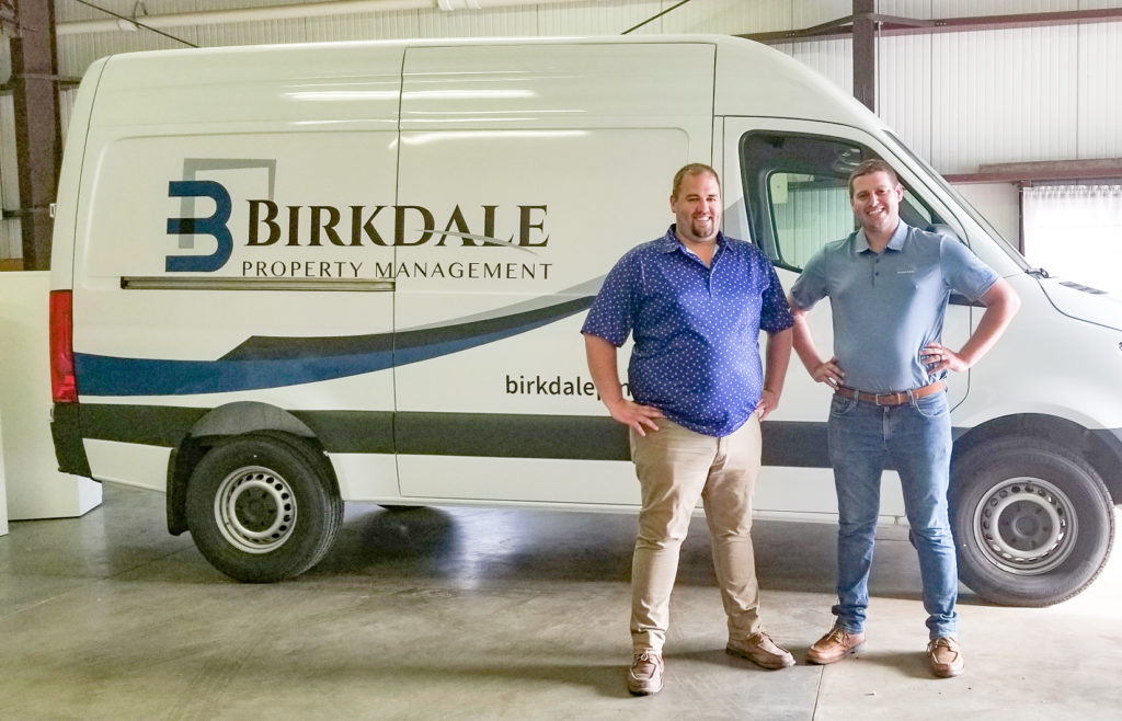 Jon and Brandon Israels posed in front of Birkdale Property Management's service van.